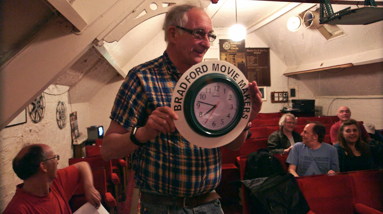 Older man holding a clock for the Bradford Movie Makers